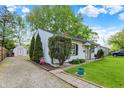 Quaint single-story home with a gravel driveway, mature landscaping, and a charming, welcoming facade at 2307 Magnolia Pl, Indianapolis, IN 46219