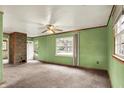 Spacious living room featuring neutral carpet, a stone accent wall, and large windows for natural light at 2307 Magnolia Pl, Indianapolis, IN 46219