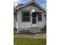 Close up of the home's front entrance with small porch awning and chain link fence at 2414 S Rybolt Ave, Indianapolis, IN 46241