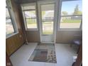 Enclosed front porch features tile flooring, a patterned rug, and lots of natural light at 2414 S Rybolt Ave, Indianapolis, IN 46241