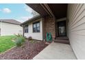 Welcoming front entry with a brick accent wall and a cozy garden bed at 3003 Foxpointe Dr, Columbus, IN 47203
