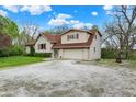Spacious two-story home with a gravel driveway, attached garage, and inviting curb appeal with mature trees at 3154 E German E Rd, Shelbyville, IN 46176
