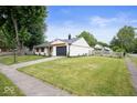 Beautiful home with a green lawn, a driveway leading to a garage, and a light-colored fence at 3864 Esquire Ct, Indianapolis, IN 46226