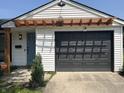 Exterior view featuring a garage and complementing pergola on a bright sunny day at 3864 Esquire Ct, Indianapolis, IN 46226