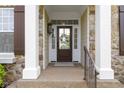 Inviting front porch with stone accents, decorative wreath, and classic architectural details at 3965 Andretti Dr, Zionsville, IN 46077