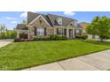 Beautiful stone home with well-maintained lawn and a welcoming front yard landscape at 3965 Andretti Dr, Zionsville, IN 46077