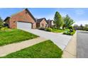 Brick home featuring a long driveway, green lawn, and mature landscaping, situated in a quiet residential neighborhood at 4316 Moss Ridge Cir, Indianapolis, IN 46237