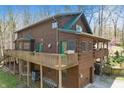 Charming log cabin with two stories, green doors, decks and nestled in a peaceful, wooded setting at 4840 N Templin Rd, Martinsville, IN 46151