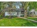 Charming single-story home features a well-manicured front yard with lush lawn and mature trees at 4914 Indianola Ave, Indianapolis, IN 46205