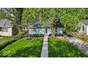 Charming single-story home features a well-manicured front yard with lush lawn and mature trees at 4914 Indianola Ave, Indianapolis, IN 46205