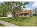 A charming single-story brick home with a well-maintained lawn and mature tree in the yard at 504 Countryside Dr, Lebanon, IN 46052