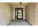 A covered front porch with concrete floor and a glass front door with side window at 504 Countryside Dr, Lebanon, IN 46052