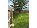 Fenced backyard with a well-maintained lawn, ideal for outdoor activities at 5327 Traditions Dr, Indianapolis, IN 46235