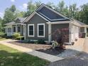 Well-maintained home showcasing an attached garage and landscaped garden with a dog statue at 5607 E 500 N, Greenfield, IN 46140