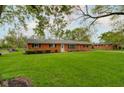 Inviting brick home with a spacious lawn, trimmed bushes, and an idyllic neighborhood setting at 5846 Linton Ln, Indianapolis, IN 46220