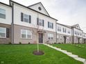 Inviting townhouse complex featuring well-kept lawns and classic architectural details at 6216 Cascades Dr, Whitestown, IN 46075