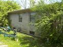 A stone-sided house with some landscaping features and the back of a trailer visible in the yard at 6736 E Michigan St, Indianapolis, IN 46219