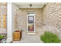 Close-up of a brick-covered front porch showing the detailed door, brickwork, and plants at 6758 Woodcliff Cir, Zionsville, IN 46077