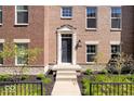 Charming brick townhome entrance featuring elegant trim, landscaping, and a welcoming walkway, blending style and comfort at 9422 Oakley Dr, Indianapolis, IN 46260
