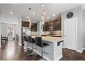 Modern kitchen with a granite island, dark cabinetry, stainless steel appliances, and stylish pendant lighting at 9422 Oakley Dr, Indianapolis, IN 46260