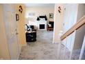 Elegant foyer with marble floors leading to a cozy living room with fireplace at 10691 Morristown Ct, Carmel, IN 46032