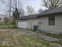 Detached garage with a white door and adjacent access door, enhanced by a practical gravel area at 1354 Roache St, Indianapolis, IN 46208