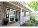 Inviting front porch with brick decor, black accents, potted plants, and a welcoming doormat at 14153 Jasmine Ct, Fishers, IN 46038