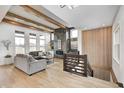 Bright living room featuring wood beams, modern fireplace, neutral decor, and staircase at 16457 Gleneagles Ct, Noblesville, IN 46060