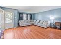 Bright living room with big sectional, blue walls and wood floors, offering a cozy space to relax and unwind at 1725 Medford Ave, Indianapolis, IN 46222