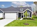 Attractive home featuring dark siding, white trim, dormer window, manicured front yard and attached garage at 19437 Astoria Ave, Sheridan, IN 46069