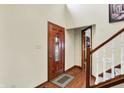 Inviting foyer featuring a decorative wood door, hardwood floors, and a staircase leading to the upper level at 195 Lake Dr, Greenwood, IN 46142