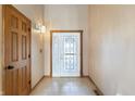 Bright foyer featuring a decorative glass front door, tiled flooring, and paneled wooden door at 2557 Cedarcrest Dr, Columbus, IN 47203