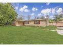 Low angle view of tan brick home with red shutters and a green lawn at 3008 Old State Road 37, Greenwood, IN 46143