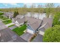 Aerial view of single-Gathering homes backing onto the lake, with well-manicured lawns at 3136 River Bay N Dr, Indianapolis, IN 46240