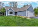 Charming single-Gathering home with a two-car garage and a well-manicured lawn and flowerbeds at 3136 River Bay N Dr, Indianapolis, IN 46240