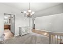 Bright entryway with carpet and wood floors, featuring a modern chandelier at 4264 Amesbury Pl, Noblesville, IN 46062