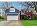 Charming two-story blue home with brick accents, a two-car garage, and a well-manicured lawn at 524 Deerberry Dr, Noblesville, IN 46062