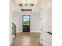 Inviting entryway features hardwood floors, a wooden door, and stairs with a wrought iron railing at 579 Exmoor Dr, Carmel, IN 46032