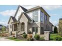 Elegant home showcasing light brick, contrasting white accents, and meticulous landscaping at 579 Exmoor Dr, Carmel, IN 46032