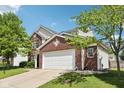 Side angle view of the house showcasing the garage, brick accents, and well-maintained lawn at 5876 E 126Th St, Carmel, IN 46033