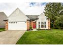 Inviting exterior showcasing a well-manicured lawn and attached two-car garage at 6140 King Lear Ln, Indianapolis, IN 46254