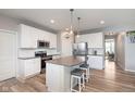 Well-designed kitchen with white cabinets, center island with seating, stainless steel appliances, and wood-look floors at 6164 Brighton Dr, Whitestown, IN 46075
