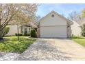 Well-maintained home with a two-car garage, green lawn, and mature landscaping, presenting great curb appeal at 6195 Woodmill Dr, Fishers, IN 46038