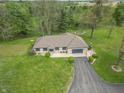 Expansive aerial view of a ranch-style home featuring a long driveway and large, well-manicured lawn at 6212 Rocklane Rd, Greenwood, IN 46143