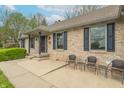 Inviting front porch with chairs and a table on a brick home, perfect for relaxing outdoors at 6212 Rocklane Rd, Greenwood, IN 46143