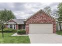 Charming single-story home featuring brick accents, a well-manicured lawn, and an attached two-car garage at 6337 Whitaker Farms Dr, Indianapolis, IN 46237