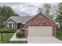Charming single-story home featuring brick accents, a well-manicured lawn, and an attached two-car garage at 6337 Whitaker Farms Dr, Indianapolis, IN 46237