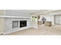 Open-concept living room with brick fireplace flows seamlessly into the updated kitchen area at 6352 Watercrest Way, Indianapolis, IN 46278