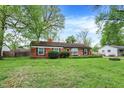 A well-maintained red brick home with neat landscaping and vibrant green lawn at 6837 Doris Dr, Indianapolis, IN 46214