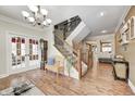 Spacious foyer with hardwood floors, chandelier, stairway with iron spindles, and access to other rooms at 7653 Carriage House Way, Zionsville, IN 46077